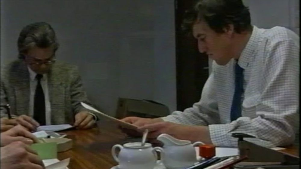 Ondertekening aan een tafel in de korte archiefmontage